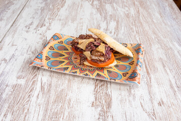 Delicious sandwich with muffin bread with loin stewed with brie cheese and tomato slices