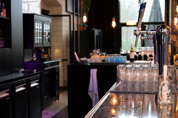 Interior of classic bar with beer taps and empty glasses in cafe