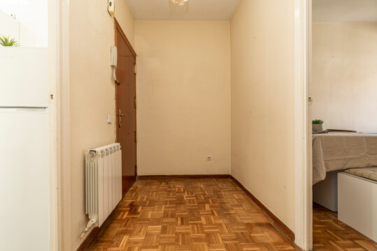 Distributor corridor of a residential house with entrance to a furnished living room and oak parquet floors