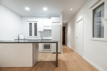 Living room with open kitchen with island with gray stone top and furniture and appliances in the background
