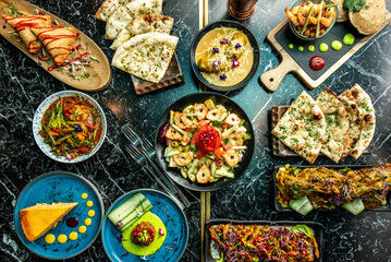 Indian food dishes with curry, korma, carrot cake, stuffed samosas, garlic bread, naan, vindaloo, tikka masala, palak paneer and onion bhaji