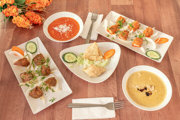 Typical Indian food dishes with red curry, yellow korma, coconut, forks, kofta and grilled lamb skewer