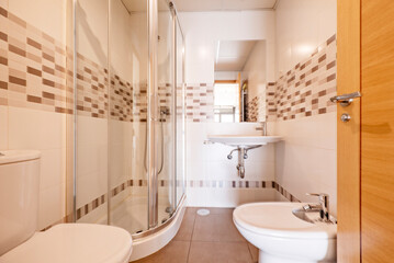 Bathroom with sink, bidet, quarter-round shower cabin, recessed mirror and wide border