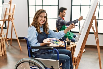 Two hispanic students smiling happy painting at art school.