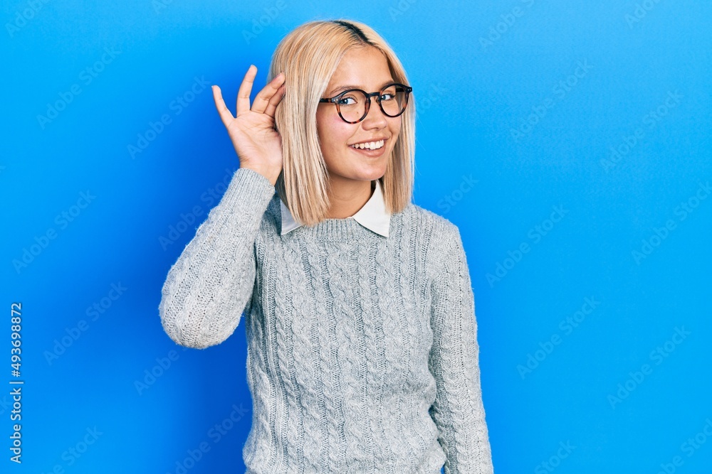 Sticker Beautiful blonde woman wearing glasses smiling with hand over ear listening an hearing to rumor or gossip. deafness concept.