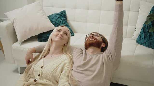 content caucasian couple celebrating Valentine's Day laying on the floor, looking up, and smiling. High quality 4k footage