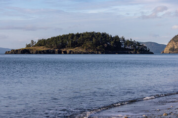 calm ocean with green forested island on sunny day