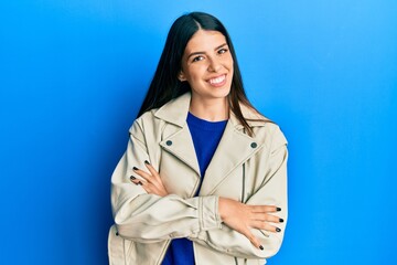 Young hispanic woman wearing casual leather jacket happy face smiling with crossed arms looking at the camera. positive person.