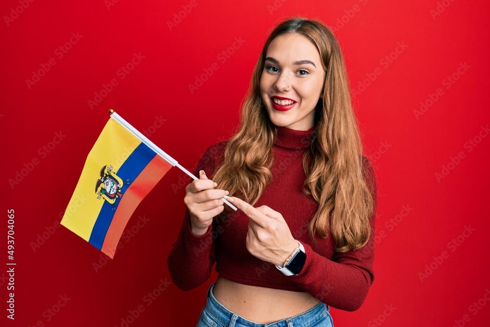 Sticker young blonde woman holding ecuador flag smiling happy pointing with hand and finger