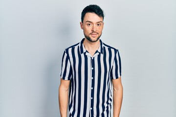 Young hispanic man wearing casual clothes relaxed with serious expression on face. simple and natural looking at the camera.