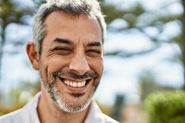 Fototapeta premium Middle age grey-haired man smiling happy standing at the city.