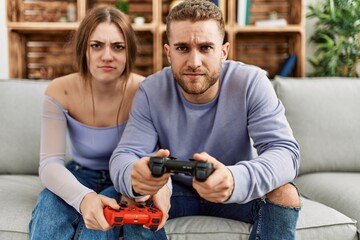 Young caucasian couple concentrated playing video game at home.