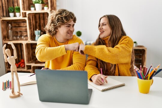 Young caucasian couple bump fists having online art class at home