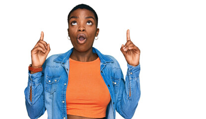 Young african american woman wearing casual clothes amazed and surprised looking up and pointing with fingers and raised arms.