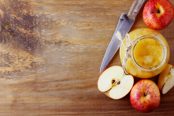 homemade apple sauce or apple puree in glass bowl over rustic wooden table