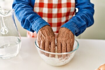 Senior man cooking dough at kitchen