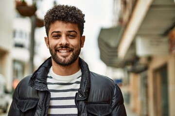 Fototapeta premium Young arab man smiling outdoor at the town