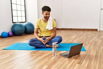 Young arab sporty man smiling happy using laptop at sport center.