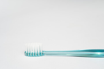 part of blue toothbrush. Toothbrush closeup on white background.