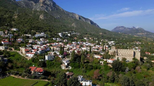 Aerial 4K view of beautiful Bellapais Village with Bellapais Monastery in Kyrenia, North Cyprus surrounded with an amazing green Mediterranean nature and picturesque landscapes in Cyprus.