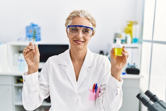 Middle age blonde woman working at laboratory smiling with a happy and cool smile on face. showing teeth.