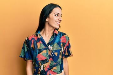 Young hispanic woman wearing casual clothes looking to side, relax profile pose with natural face and confident smile.