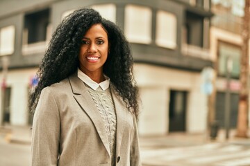 Fototapeta premium Middle age african american businesswoman smiling happy standing at the city.