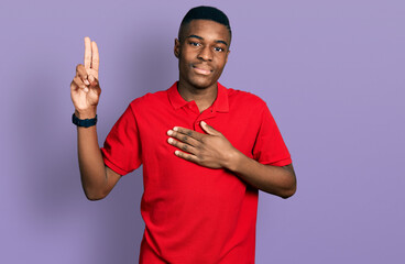 Young african american man wearing casual red t shirt smiling swearing with hand on chest and...