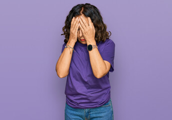 Middle age hispanic woman wearing casual clothes with sad expression covering face with hands while...