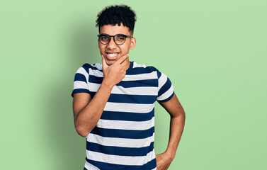 Young african american man wearing casual clothes and glasses looking confident at the camera...