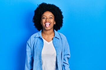 Fototapeta na wymiar Young african american woman wearing casual clothes sticking tongue out happy with funny expression. emotion concept.