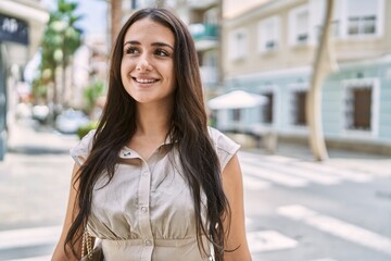 Young hispanic girl smiling happy standing at the city.