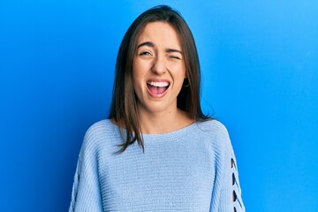Fototapeta premium Young hispanic girl wearing casual clothes winking looking at the camera with sexy expression, cheerful and happy face.