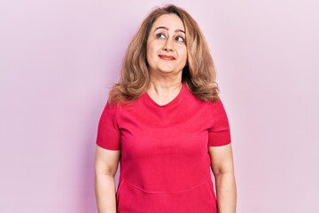 Middle age caucasian woman wearing casual clothes smiling looking to the side and staring away thinking.