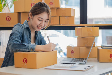 Portrait of a Small Business Startup, SME Owner, Female Entrepreneur Asian girl working on boxes...