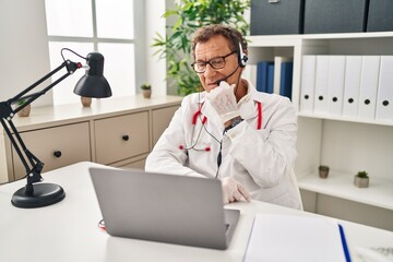 Senior doctor man working on online appointment looking stressed and nervous with hands on mouth biting nails. anxiety problem.