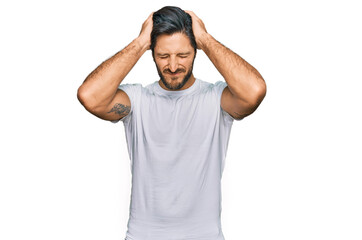 Young hispanic man wearing casual white t shirt suffering from headache desperate and stressed because pain and migraine. hands on head.