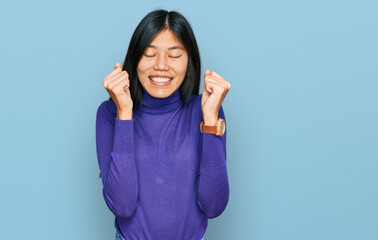 Fototapeta premium Beautiful young asian woman wearing casual clothes excited for success with arms raised and eyes closed celebrating victory smiling. winner concept.