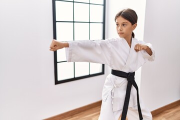 Young hispanic girl doing martial arts at training studio - obrazy, fototapety, plakaty