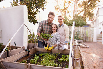 Green thumb family. Portrait of a happy family gardening together in their backyard.