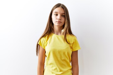 Young brunette teenager standing together over isolated background relaxed with serious expression...