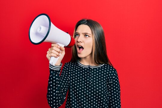 Young teenager girl shouthing and screaming with megaphone