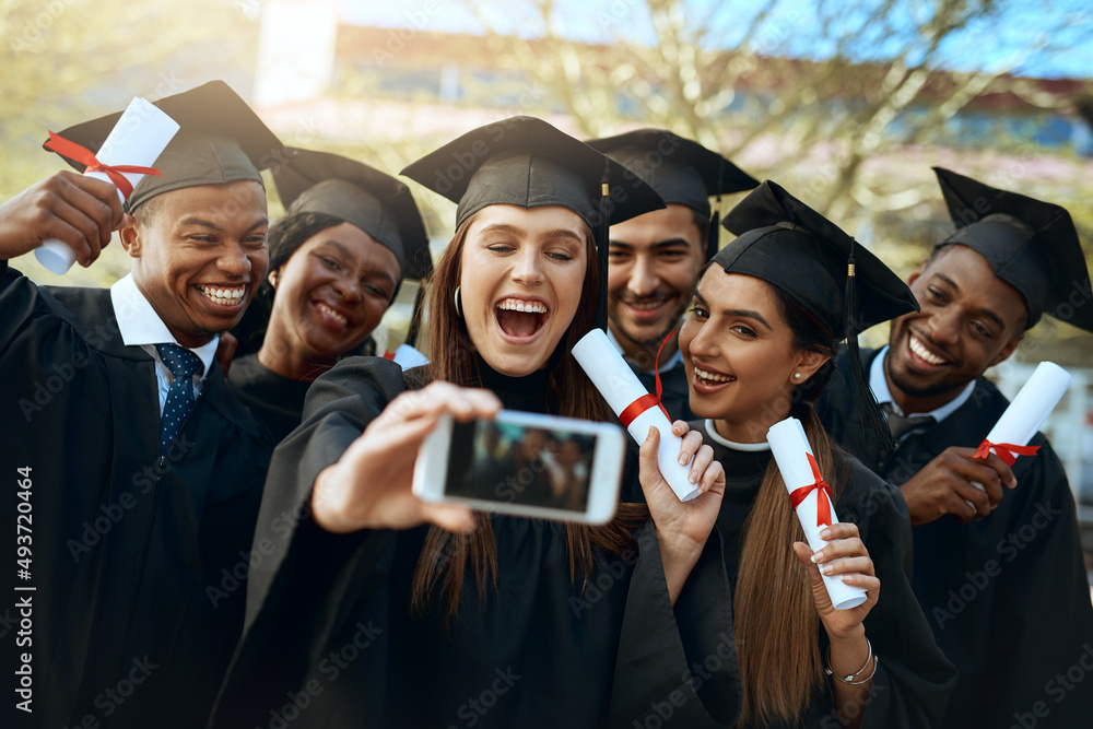 Poster working world, here we come. shot of a group of students taking selfies with a mobile phone on gradu