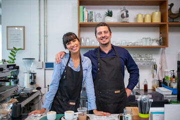 Portrait of smiling owner man standing at his cafe. Coffee owner standing with apron in coffee shop...