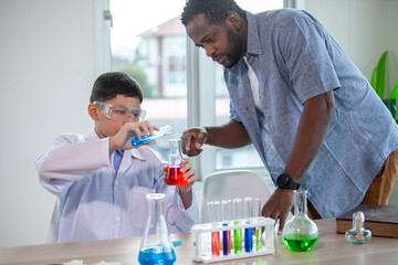 Students mixes chemicals in beakers. enthusiastic teacher explains chemistry to children, chemistry student showing new experiment to teacher science class