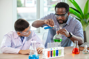 Students mixes chemicals in beakers. enthusiastic teacher explains chemistry to children, chemistry student showing new experiment to teacher science class