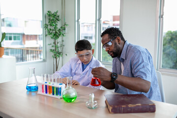 Students mixes chemicals in beakers. enthusiastic teacher explains chemistry to children, chemistry student showing new experiment to teacher science class