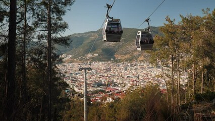 Cable car cabins moving on rope way for passenger transportation with cityscape