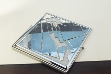 Broken mirror with silver frame on white background