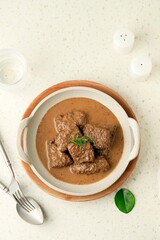 Daging Kelem is a traditional food from Central Java, Indonesia, made from beef, coconut milk and spices. It tastes sweet and savory. Served in bowl, close up.